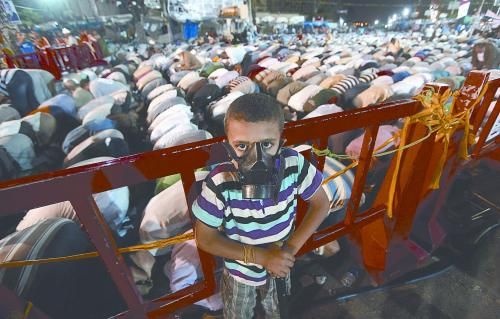 當(dāng)?shù)貢r間28日晚，在埃及開羅納賽爾城，一名小男孩頭戴防毒面具參加穆兄會的集會示威。