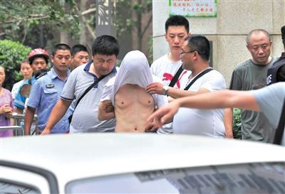 昨日，成都警方抓捕時與毒犯發(fā)生槍戰(zhàn)。一名男犯罪嫌疑人被警方押出。
