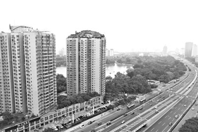 昨日，人濟(jì)山莊小區(qū)，與其他樓相比，B棟樓頂層天臺上違規(guī)建造了一棟兩層小樓，假山大樹俱全。新京報(bào)記者