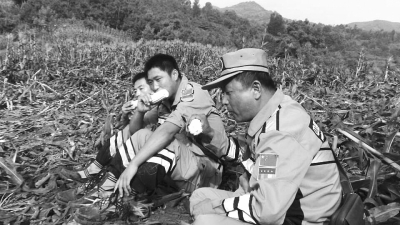 饑餓難忍，中國(guó)緊急救援河南基地的救援隊(duì)員在已毀的玉米地里撿拾生玉米吃。