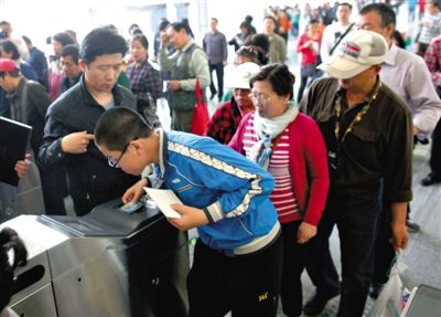 去年5月5日，14號(hào)線(xiàn)園博園站，乘客刷卡出地鐵。北京公交地鐵將實(shí)行計(jì)程票制，多乘坐多付費(fèi)。