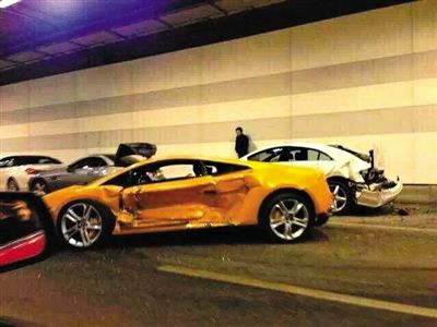 一目擊者出示照片，隧道內，事發(fā)時還停著多輛車，其中一輛黃色豪車車門明顯內凹，另一白色車車尾損毀嚴重。