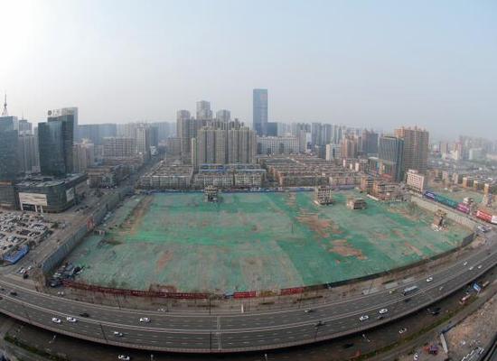 2016年4月，經(jīng)過持續(xù)攻堅，親賢社區(qū)西北片區(qū)的拆遷工作基本告一段落，但在鋪設(shè)了防塵綠網(wǎng)的空地中，至今仍有3戶居民選擇了“堅守”。(拍攝：2016年4月4日)