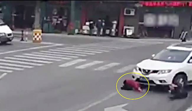 圖為小姑娘被卷進(jìn)車輪下瞬間。