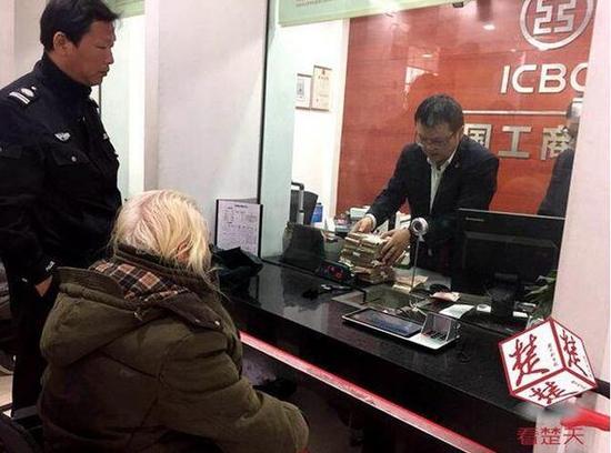 工作人員帶著老人去存錢(qián)