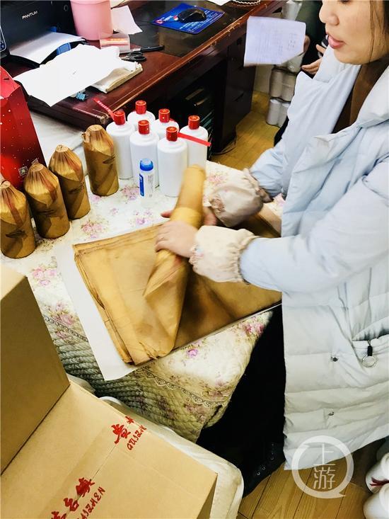 正在對(duì)白酒進(jìn)行包裝處理的經(jīng)營(yíng)戶。