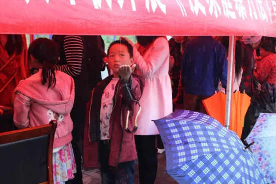 因為雨下的太大，小男孩玩起了接水游戲。