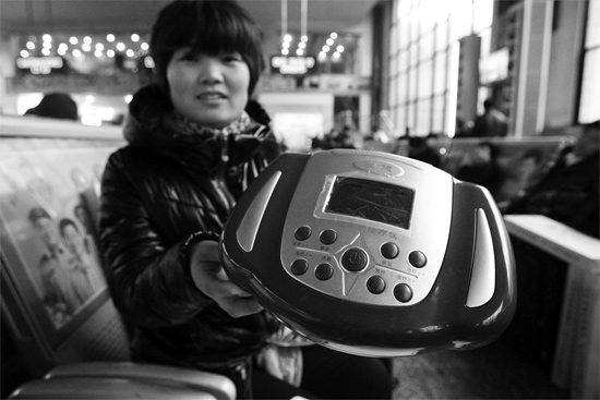 火車站候車室，李女士向記者展示她準備孝敬父母的按摩儀