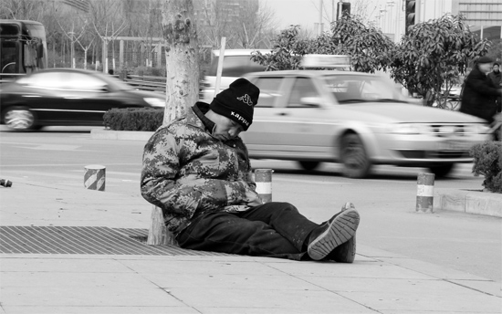 2月2日，鄭州市中州大道農(nóng)業(yè)路立交橋下，50歲的王文德打算在臨近春節(jié)前再接些零活兒，由于疲憊，他睡著