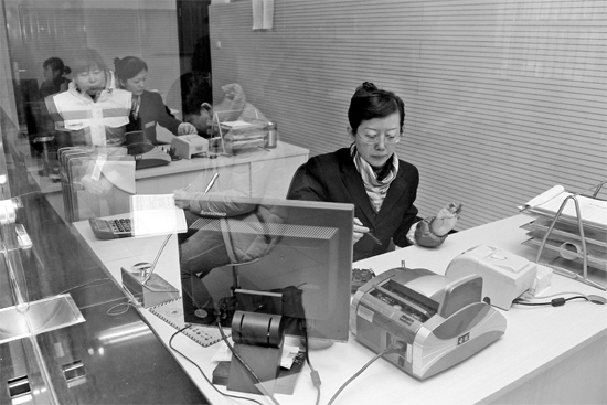 2月16日，鄭州市自來水總公司鄭東新區(qū)一營業(yè)廳，柜臺內(nèi)工作人員正在為市民辦理業(yè)務