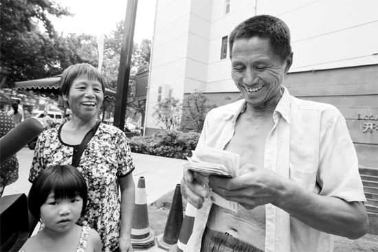 昨日，鄭州市明達路與豐慶路交叉口西300米路南，來自中牟的瓜農(nóng)拿到西瓜款，笑開顏東方今報記者袁曉強