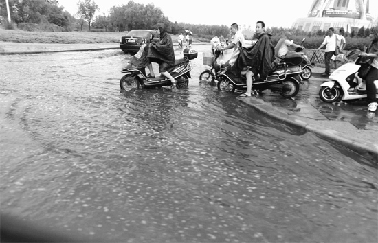 8月7日，鄭州一場(chǎng)暴雨，鄭州多處干道被淹，市民行路如過(guò)河