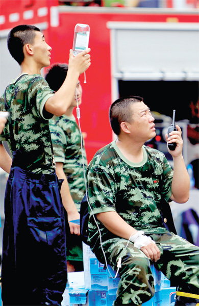 火場外，被消防戰(zhàn)士稱為“李大隊(duì)”的救援人員掛著吊瓶現(xiàn)場指揮