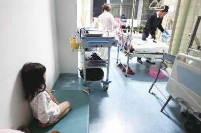 嘟嘟一早就醒了，小小的身體靠在墻邊看著爸爸進行手術前準備