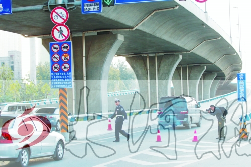 交警在東風(fēng)路從北向南上橋口處擺上反光錐，間歇放行