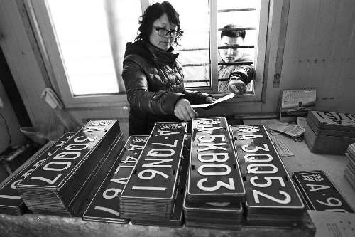 鄭州市車(chē)管所工作人員正忙著把新制作的車(chē)牌發(fā)給等待的車(chē)主