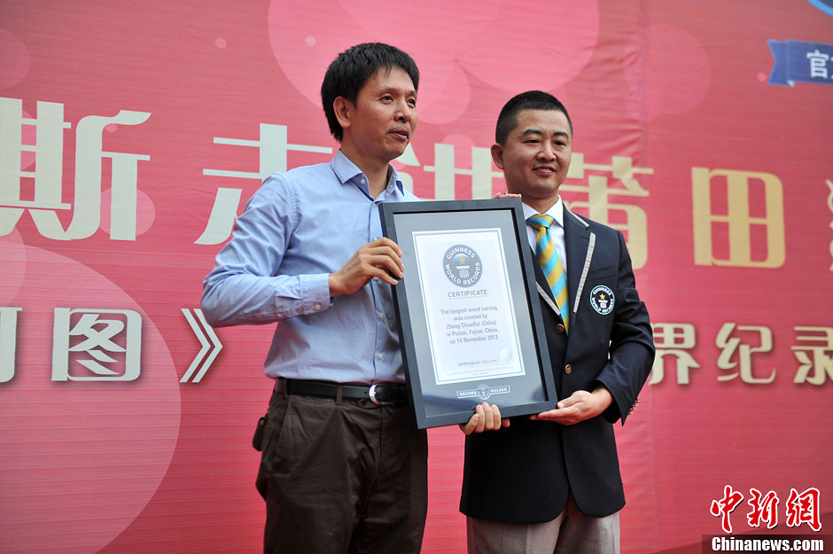 圖為世界吉尼斯認證官為鄭春輝（左）頒發(fā)證書。呂明 攝