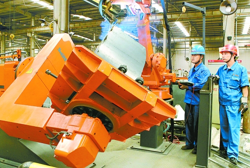 圖為龍工集團(tuán)中原公司的職工正在操作機(jī)器人焊接裝載機(jī)。