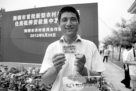 領(lǐng)到貸款，農(nóng)民開心地笑了。