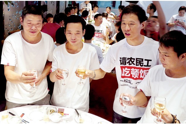 活動發(fā)起人張楠（右二）給農民工敬酒。