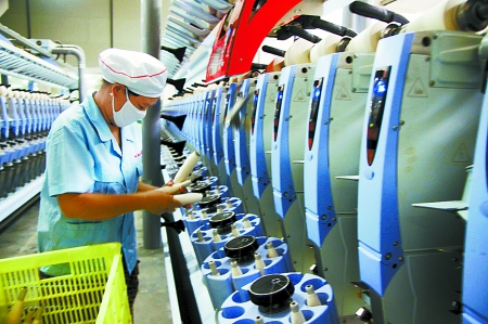 7月3日，在鄧州市永泰棉紡有限公司電腦控制全自動紡紗車間，紡織工人正在生產(chǎn)棉紗。