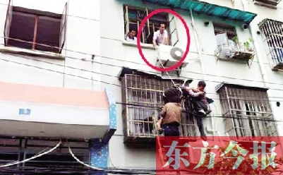 施救現(xiàn)場(chǎng)，劉鵬（圈內(nèi)）先用繩子捆住老太確保安全 勞動(dòng)報(bào)記者 郭娜 供圖