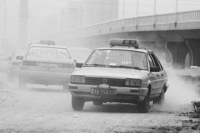 施工的道路上，車輛通過塵土飛揚(yáng)。