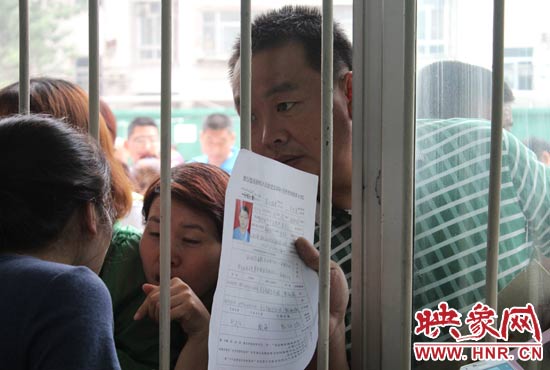 不少家長(zhǎng)擠在報(bào)名窗口前咨詢報(bào)名事宜。