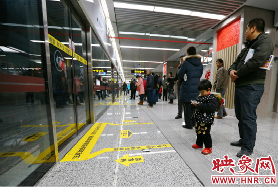 小朋友在等候區(qū)內(nèi)等待地鐵。