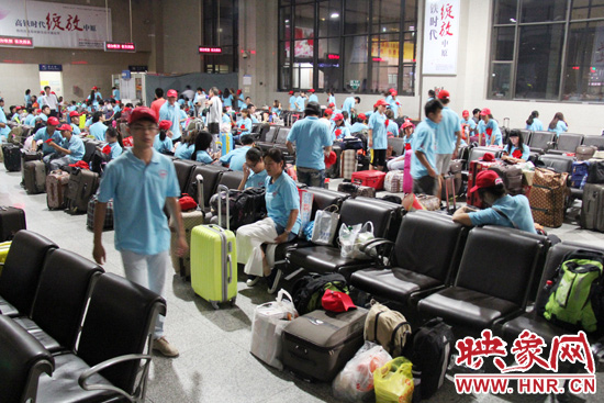 大學(xué)生志愿者在火車站候車室內(nèi)整裝待發(fā)。