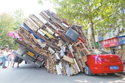 紅色小轎車被砸，卡在路邊動彈不得。