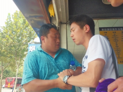 記者正查看照片，突遭藍(lán)衣男強搶手機。