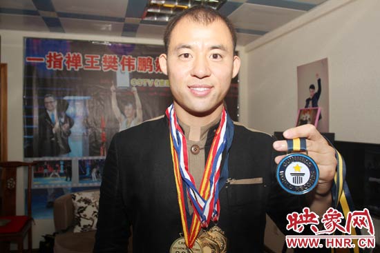 樊偉鵬向大家展示自己剛獲得的吉尼斯獎(jiǎng)牌。