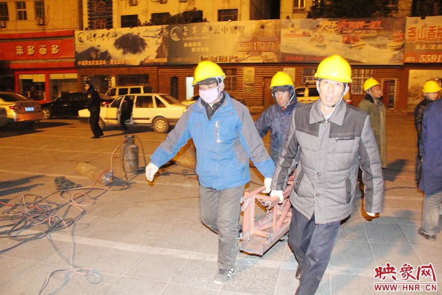 23點(diǎn)56分，第一塊兒廣告牌已經(jīng)分割完畢，地面上的20多名工人將拆除下來的鋼件撞車運(yùn)走。