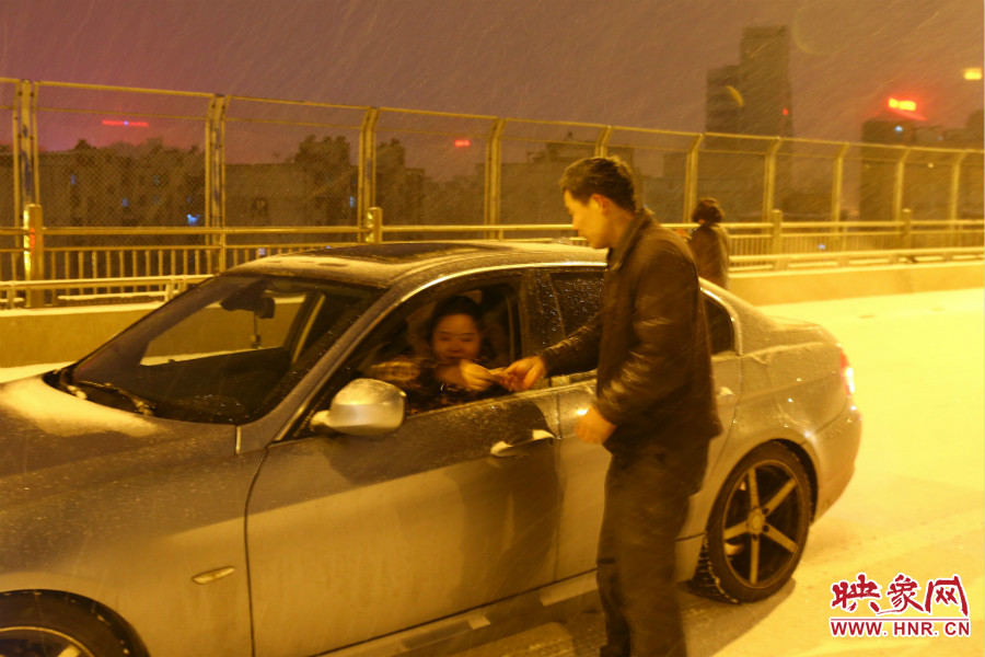 “推車人”幫助一輛車上坡后，收取“勞務費”。