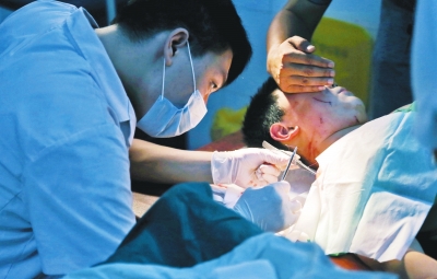 孩子身上有7道傷痕，其中兩道需要縫合，其他的均為擦傷，醫(yī)生正對(duì)他施治。