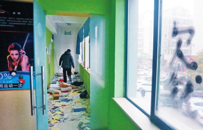 　健身會所地上一片狼藉，玻璃上噴著黑色“欠錢”二字。