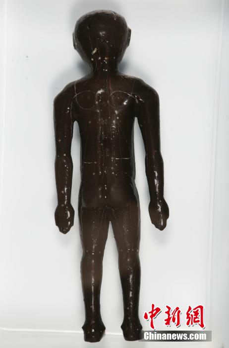 圖為出土的人體經(jīng)穴漆俑。