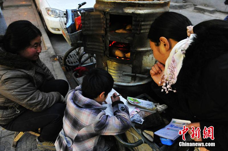 男孩西安路燈下寫作業(yè) 媽媽邊賣紅薯邊輔導(dǎo) 男孩西安路燈下寫作業(yè) 媽媽邊賣紅薯邊輔導(dǎo)