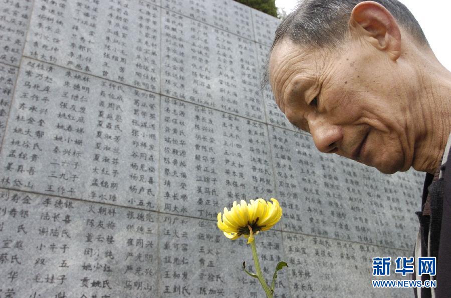 2006年4月5日，74歲的南京大屠殺幸存者佘子清手捧鮮花，祭奠被日軍殺害的母親。