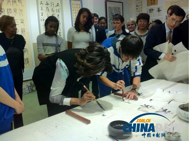 　北京時間3月21日，美國第一夫人米歇爾參觀北師大二附中時，與學(xué)生一起練習(xí)書法。