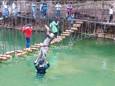 中年男游客正踩著景區(qū)安全員郭小明的肩膀過河。網(wǎng)友“@我的小名叫張孩”供圖