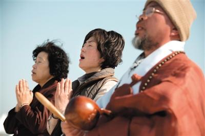 23日，一名僧侶引領(lǐng)人們?yōu)樗勒咂矶\。