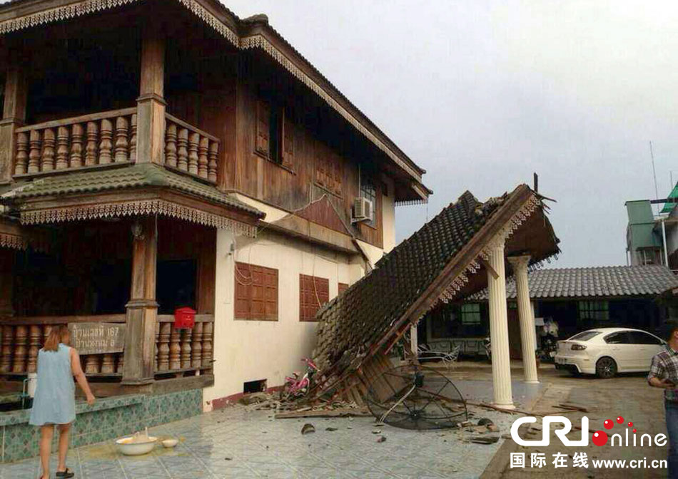 當(dāng)?shù)貢r(shí)間2014年5月5日，泰國清萊，一名婦女看著受損的房屋。 圖片來源：東方IC