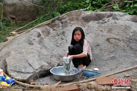 8月9日，云南巧家紅石巖村，10歲的劉鑫蕊在洗自己的衣服