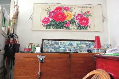 　陳會(huì)英將兒女的照片都裱起來，裝在一個(gè)大相框里，放在箱子上經(jīng)常看，其中最多的就是劉金國的照片。