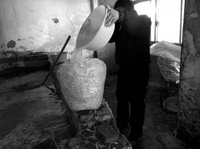 作坊內(nèi)工人用攪拌有漂白粉的藥水給豆芽增白。