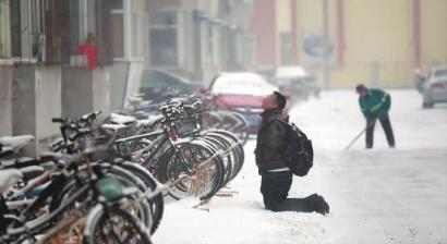 小伙子跪在樓前，一直抬頭看著樓上。 孫立國(guó)/攝