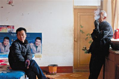 父親抽煙，兒子不語。逃跑的越南新娘，給袁迎賓父子帶來的是失落。新京報記者