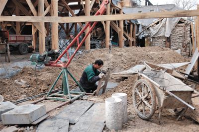 東城區(qū)北鑼鼓巷與小經廠胡同之間一處四合院內，工人進入已經挖好的地下室內施工。